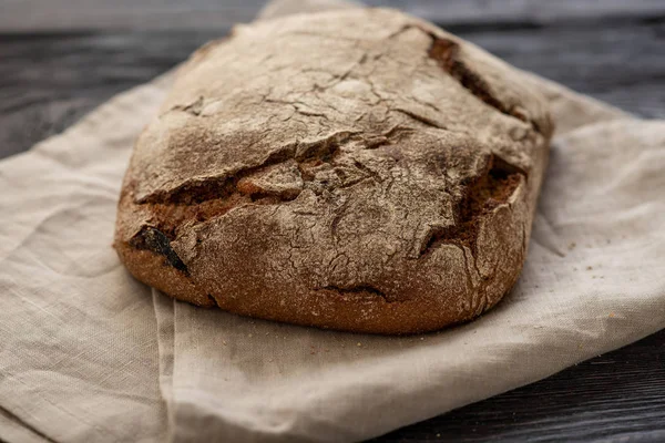 Pão caseiro está deitado em uma mesa de madeira — Fotografia de Stock