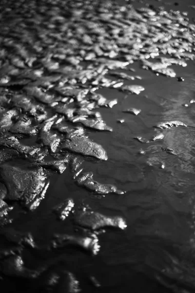 Текстура мокрого песка на солнце — стоковое фото