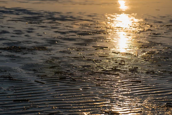 Golden wavy sand. the sand glitters in the sun after the ebb of the sea. sun flare on the shore — Stock Photo, Image