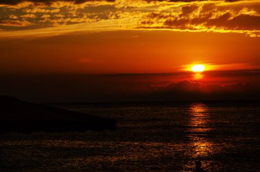 denizde parlak turuncu gün batımı