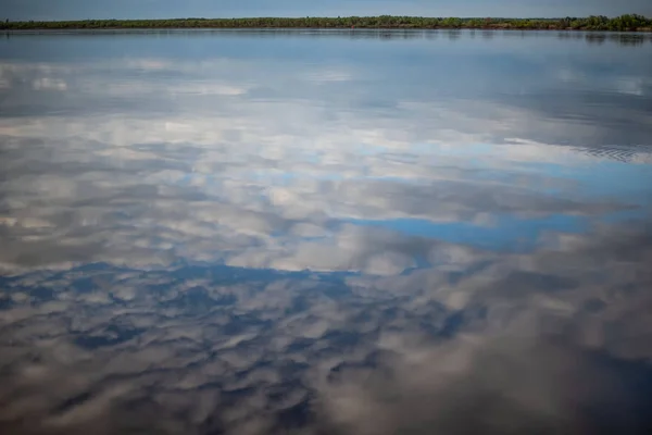 Weiße Wolken spiegeln sich im Wasser — Stockfoto