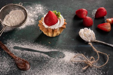 koyu bir arka plan üzerinde çilek tatlı. Çilekli kek. Un masada. Ev yapımı kek yapma süreci