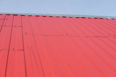 Gökyüzüne karşı kırmızı demir çarşaflarla kaplı çatı. çatı parçası