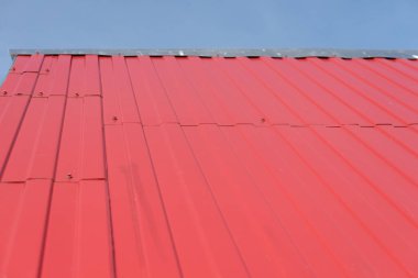 Gökyüzüne karşı kırmızı demir çarşaflarla kaplı çatı. çatı parçası