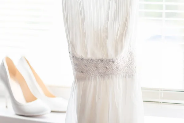 迎面而来的是一个明亮的窗玻璃 上面有一双雪白的鞋子和一件衣服 是送给新娘的 — 图库照片