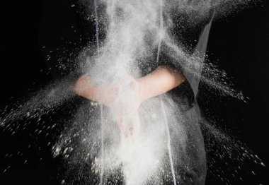 Fırıncının elleri arka planda beyaz buğday unu süzüyor.