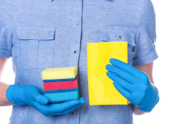 Una mano en un guante azul sostiene esponjas multicolores y un trapo amarillo para limpiar las habitaciones. sobre un fondo blanco . —  Fotos de Stock