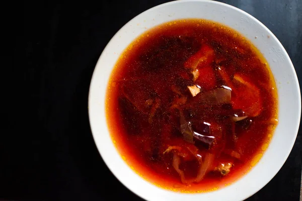 Bietensoep in een wit kopje op een zwarte achtergrond - borscht — Stockfoto