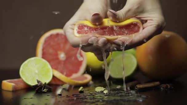 Mujer exprimiendo un pomelo fresco y jugoso con las manos. Frutas frescas — Vídeo de stock