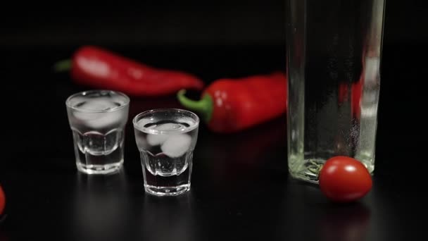 Körsbärstomat rulla upp till två koppar vodka. Svart bakgrund — Stockvideo