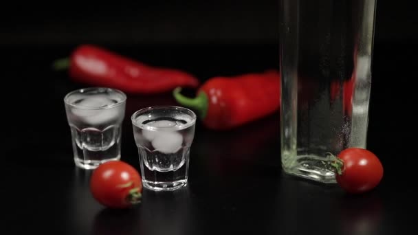 Cherry-tomaat broodje tot twee kopjes van wodka. Zwarte achtergrond — Stockvideo