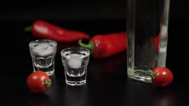 Rollo de tomate cherry hasta dos tazas de vodka. Fondo negro — Vídeos de Stock