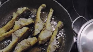 Mutfakta yemek kızarmış balık. Balık yatıyordu hangi parçalar üzerinde kaynar yağ ile pota. Kaç çekim!