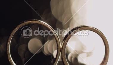 Alyans parlayan ışık ile karanlık yüzeyinde yalan makroyu kapatın. Yansıma. Siyah arka plan