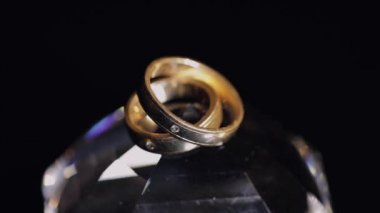 Alyans parlayan ışık ile kristal yatan makroyu kapatın. Siyah arka plan. Ağır çekim