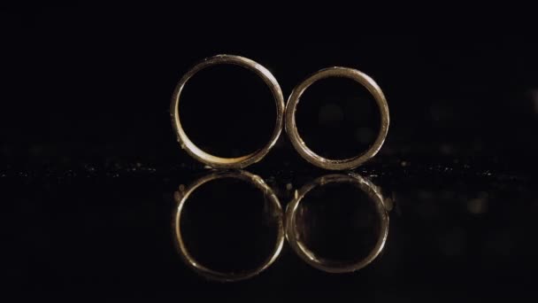 Anneaux Mariage Couchés Sur Une Surface Sombre Brillante Avec Macro — Video