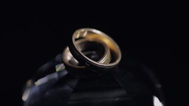 Alyans parlayan ışık ile kristal yatan makroyu kapatın. Siyah arka plan. Ağır çekim