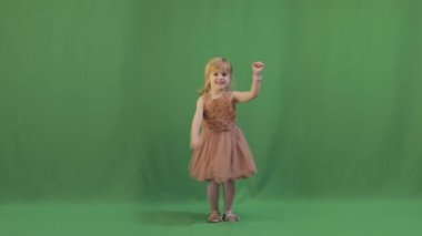 Mutlu üç yaşında bir kız. Sevimli sarışın çocuk. Kahverengi gözler. Yeşil ekran video. Dans