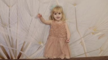 Mutlu yüzler ve dans üç yıl yaşlı kız olun. Sevimli sarışın çocuk. Kahverengi gözler. Sevimli kız gülümsüyor. Küçük çocuk, 3-4 yaşında sarışın kız