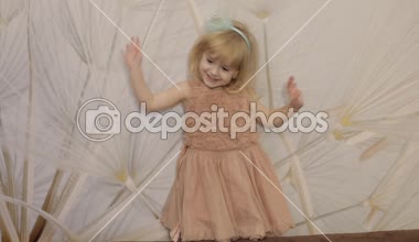 Mutlu yüzler ve dans üç yıl yaşlı kız olun. Sevimli sarışın çocuk. Kahverengi gözler. Sevimli kız gülümsüyor. Küçük çocuk, 3-4 yaşında sarışın kız