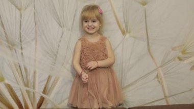 Mutlu yüzler ve dans üç yıl yaşlı kız olun. Sevimli sarışın çocuk. Kahverengi gözler. Sevimli kız gülümsüyor. Küçük çocuk, 3-4 yaşında sarışın kız