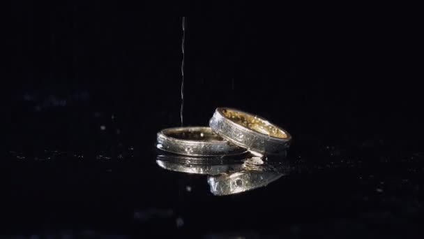 Anillos Boda Acostados Superficie Oscura Brillando Con Luz Cerca Macro — Vídeos de Stock