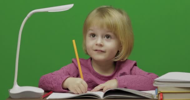 食卓を描いている女の子 教室で教育プロセス 幸せな 歳の女の子 笑っているかわいい女の子 歳のブロンドの女の子のかわいらしい子 顔を作る 緑色の画面のビデオ クロマ — ストック動画