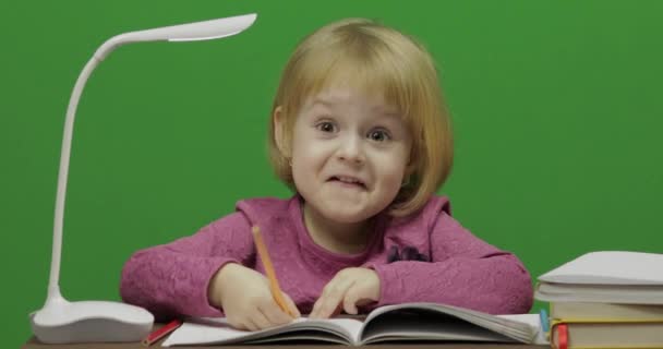 食卓を描いている女の子 教室で教育プロセス 幸せな 歳の女の子 笑っているかわいい女の子 歳のブロンドの女の子のかわいらしい子 顔を作る 緑色の画面のビデオ クロマ — ストック動画