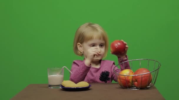Дівчина Сидить Столом Їсть Шоколад Печиво Яблука Щаслива Трирічна Дівчинка — стокове відео