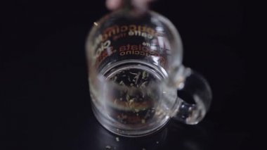 Kuru çay ekleyerek cam fincan içine bırakır. Yeşil çay hazırlama. Siyah arka plan