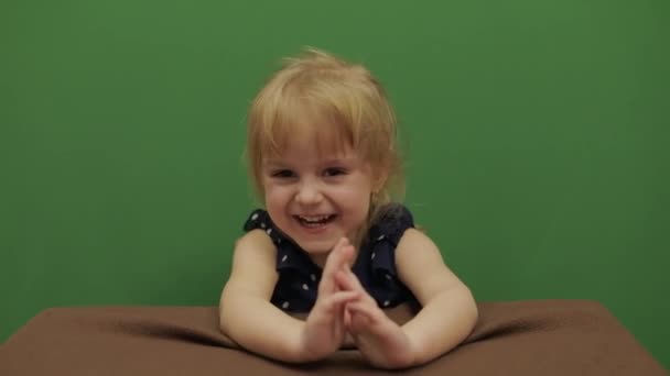女孩在桌子上 快乐的三岁女孩 可爱的女孩微笑 棕色的眼睛 漂亮的小孩3 4岁的金发女孩做鬼脸 绿色屏幕视频 色度键 — 图库视频影像