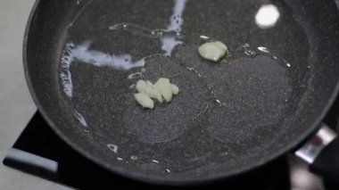 Kızarmış dilimlenmiş siyah tavada sarımsak ve kaynar gıda petrol