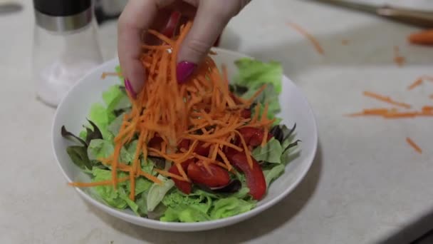 Añadir las zanahorias picadas en ensalada con pimiento rojo y ensalada de lechuga — Vídeos de Stock