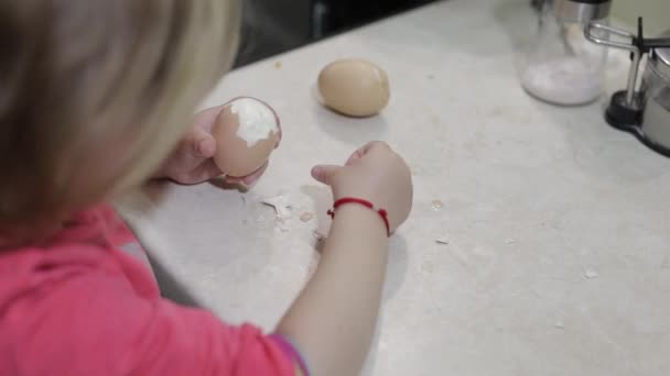 Primer plano de una niña limpia la cáscara con un huevo de gallina hervido — Vídeos de Stock