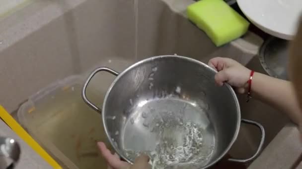 Criança lavar pratos na cozinha. Close up de mãos meninas — Vídeo de Stock