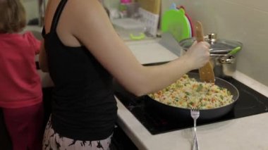Kadın pişirme kızartma yemek. Kuşkonmaz, biber, Mısır ve havuç ile incir