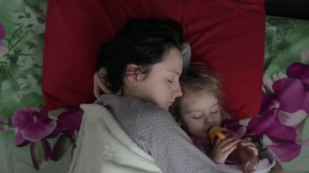Mujer joven soñolienta con su bebé no quiere despertarse por la mañana — Vídeos de Stock