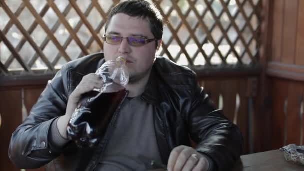 Men sit at the table and drink beer from plastic bottles. Happy — Stock Video