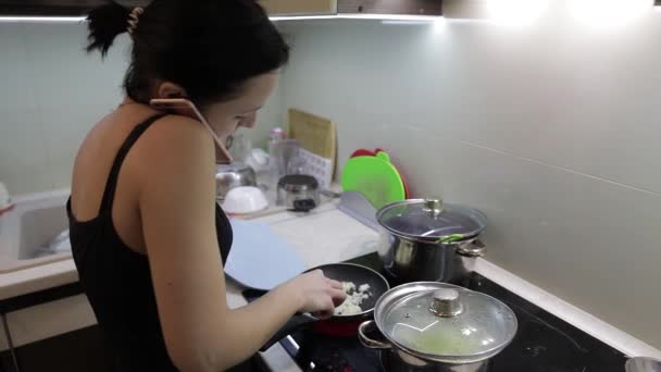 Beautiful caucasian woman talking on the phone while cooking — Stock Video
