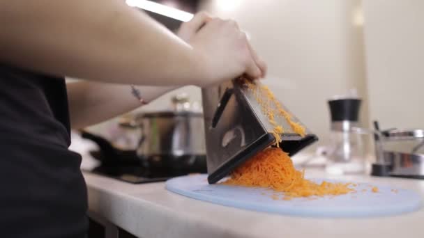 Carote su una grattugia strofinata sulla cucina di casa. Grattugia di taglio della carota — Video Stock