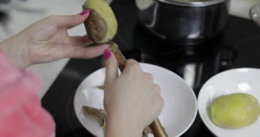 Kadın ev kadını mutfakta Soyma patates eller.