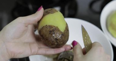 Kadın ev kadını mutfakta Soyma patates eller.