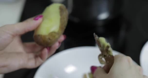 Mulheres dona de casa mãos descascando batatas na cozinha . — Vídeo de Stock