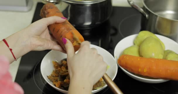 Mani casalinghe femminili peeling carota in cucina . — Video Stock