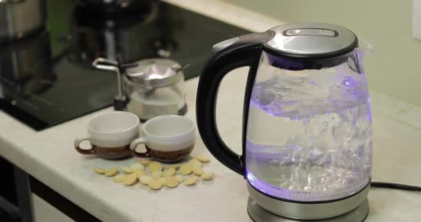 Tea kettle with boiling water. Tea bags and sugar on the background — Stock Video