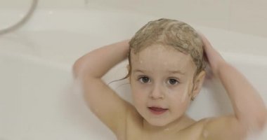 Çekici üç yaşında kız banyo yapsın. Temizleme ve saç yıkama
