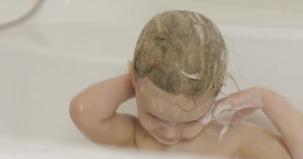 Attractive three years old girl takes a bath. Cleaning and washing hair — Stock Video