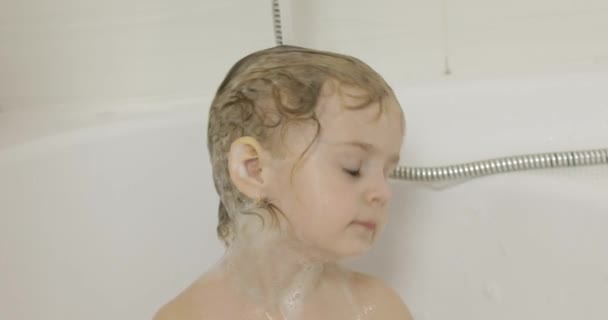 Atraente menina de três anos toma banho. Limpeza e lavagem de cabelo — Vídeo de Stock