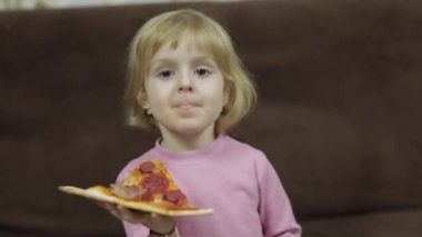 Sevimli küçük beyaz kız pizza yemek. Pizza tarafından bir ısırık alarak aç çocuk