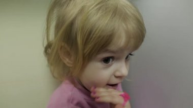 Küçük bir sarışın sevimli kız yüzünü kapat. Gülümseyen kız. İçeride. Portre vurdu